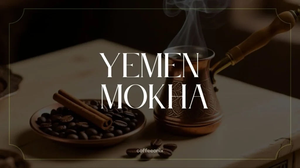 Yemen Mokha coffee beans beside a copper cezve and cinnamon sticks, representing traditional mocha aroma and spice warmth.